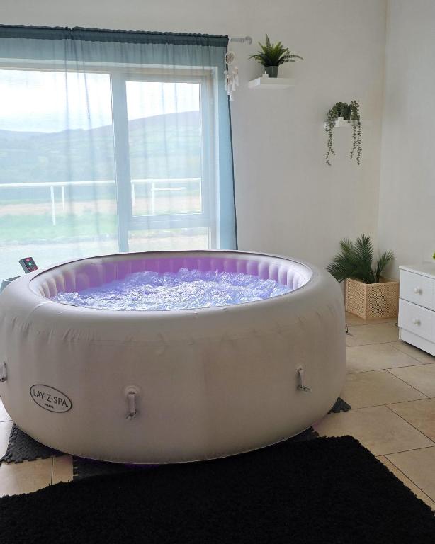 a large bath tub in a room with a window at Ballycrystal House Getaway in Bunclody