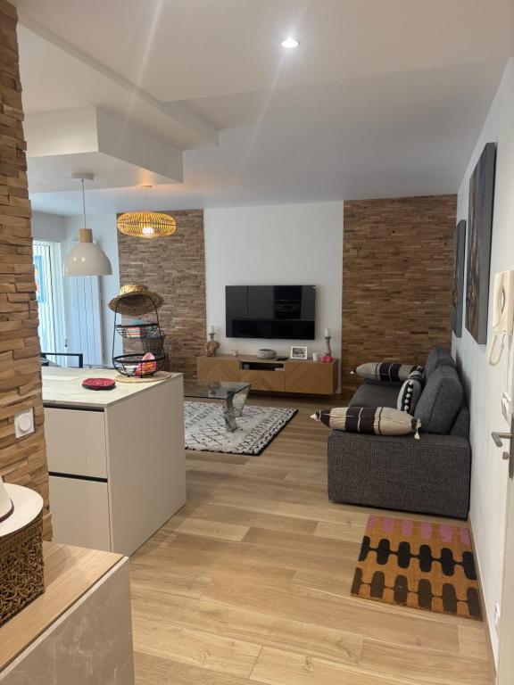 a living room with a couch and a kitchen at La Milady in Biarritz