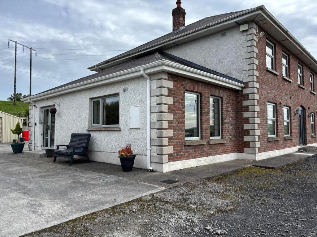 Una casa de ladrillo con un banco delante de ella. en apartment cavan, en Cavan
