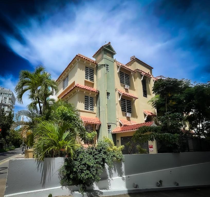 a yellow building with palm trees in front of it at Canario Boutique Hotel in San Juan