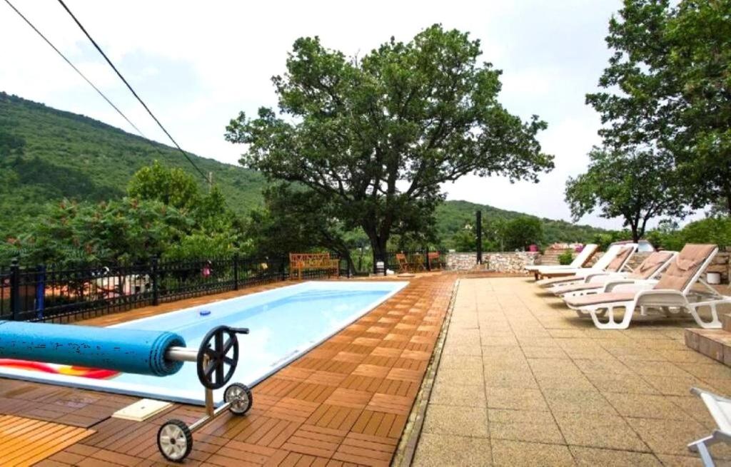 a swimming pool with lounge chairs and a swimming pool at House Golovik in Brseč