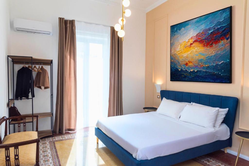 ein Schlafzimmer mit einem Bett und einem Gemälde an der Wand in der Unterkunft Suites Cavour holiday dream in Palermo