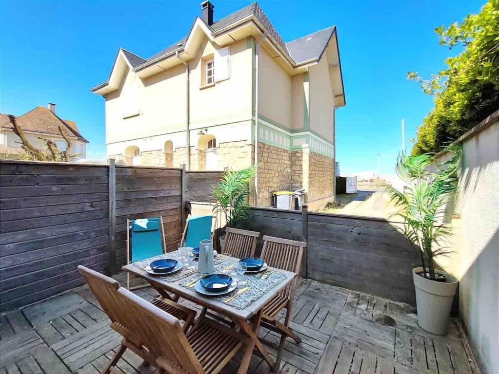 een terras met een tafel en stoelen en een gebouw bij Cosy Villa by sea ! - two terraces in Ouistreham