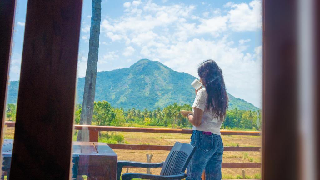 a woman looking out a window at a mountain at Diamond Mount Villa in Dambulla