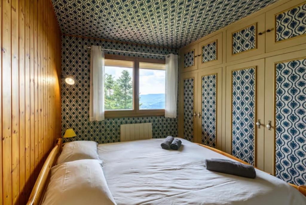une chambre avec un grand lit avec une fenêtre dans l'établissement Chalet SOL LA MI, à Soultzeren