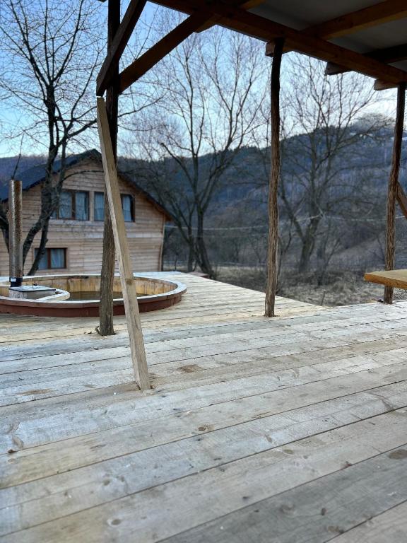 a wooden deck with a bench and a building at Montain Cabin Apuseni in Săgagea
