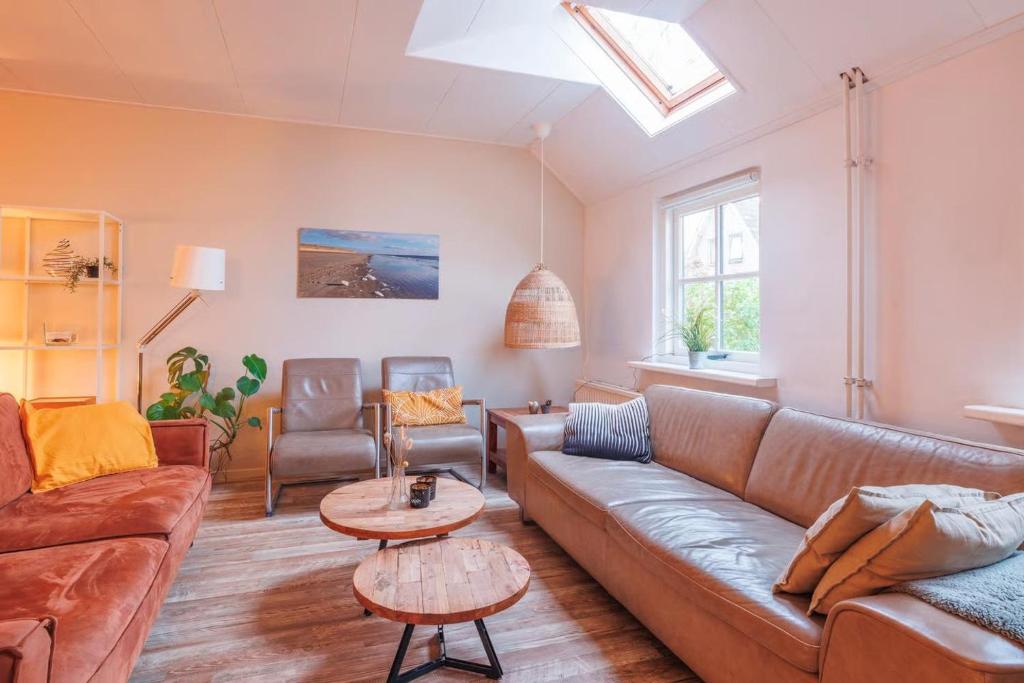 a living room with a couch and a table at Naar Zee op Ameland in Buren