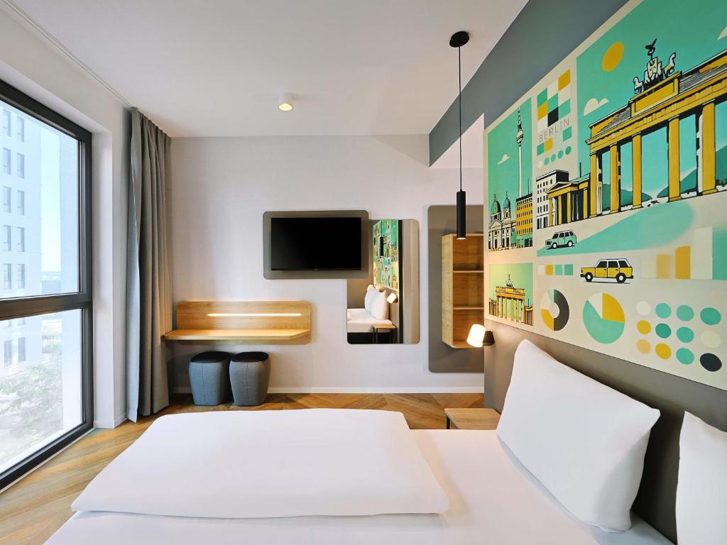a hotel room with a bed and a flat screen tv at B&B HOTEL Berlin Airport-Nord in Berlin