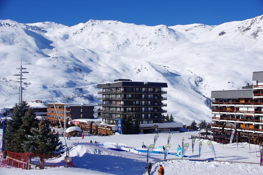a ski resort in the snow with mountains in the background at Résidence Lac du Lou - Les Ménuires in Les Menuires