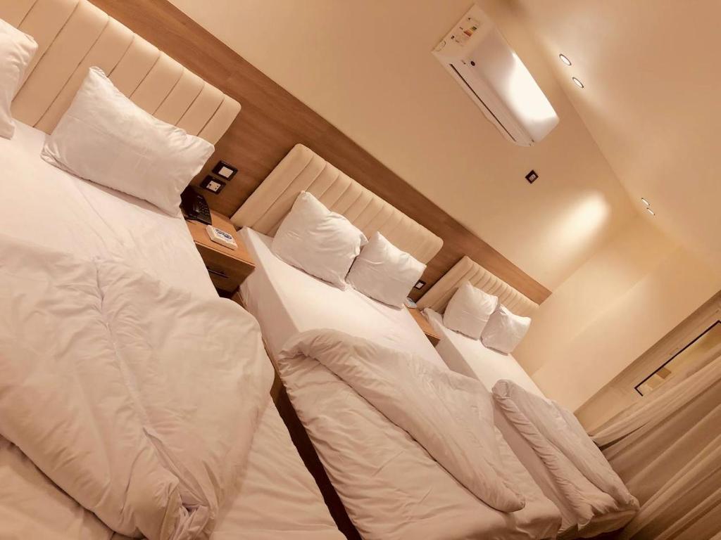 two beds in a hotel room next to each other at Amigo de Las pirámides in Cairo