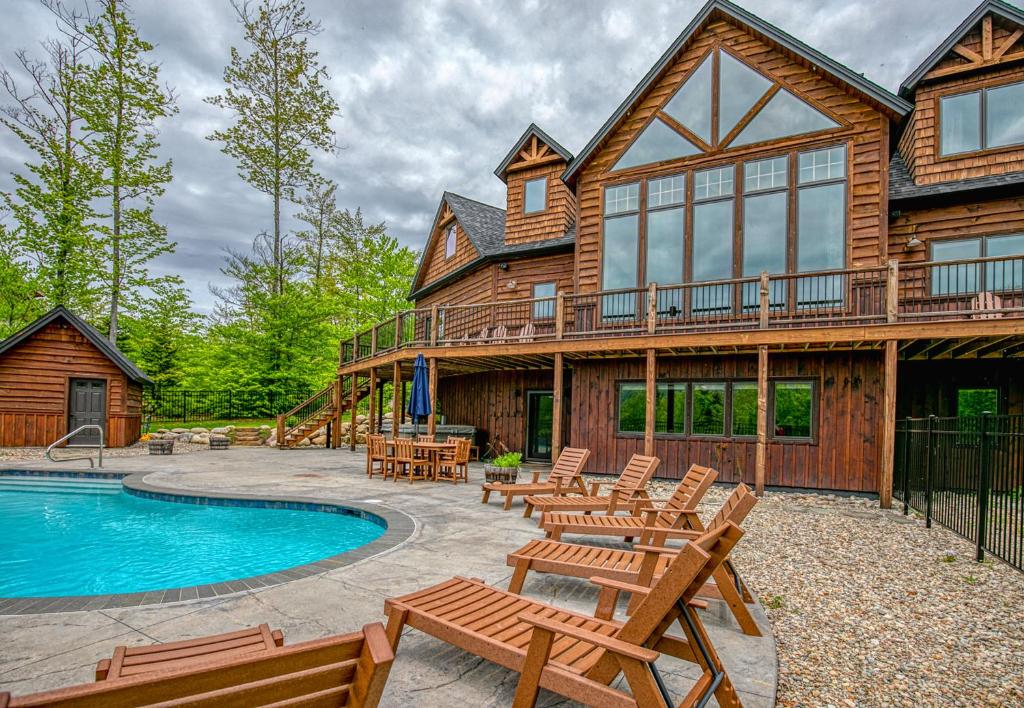 a log house with a swimming pool and chairs at Mountain Estate Main House in Newry