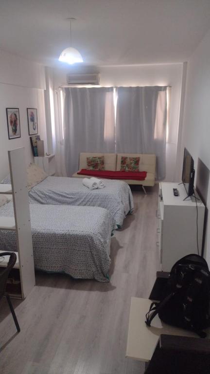 a bedroom with a bed and a desk with a television at Hermoso Departamento En El Centro De Buenos Aires in Buenos Aires