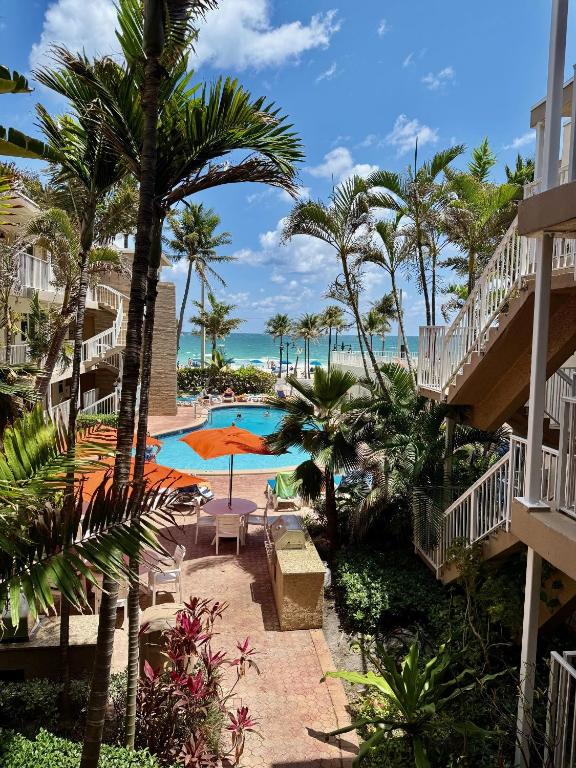 a view of the pool and beach from the balcony of a resort at Silver Seas Beach Resort in Fort Lauderdale