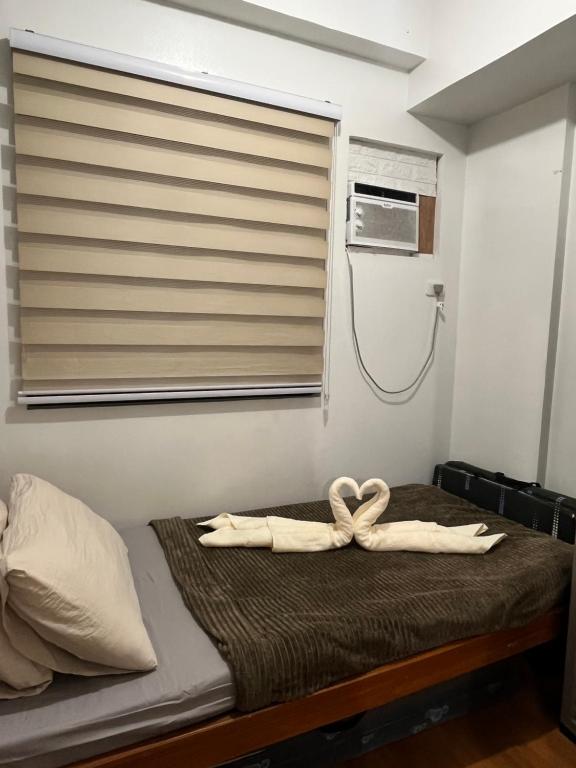 ein Bett mit zwei weißen Handtüchern auf einem Zimmer in der Unterkunft Camella Northpoint in Davao City