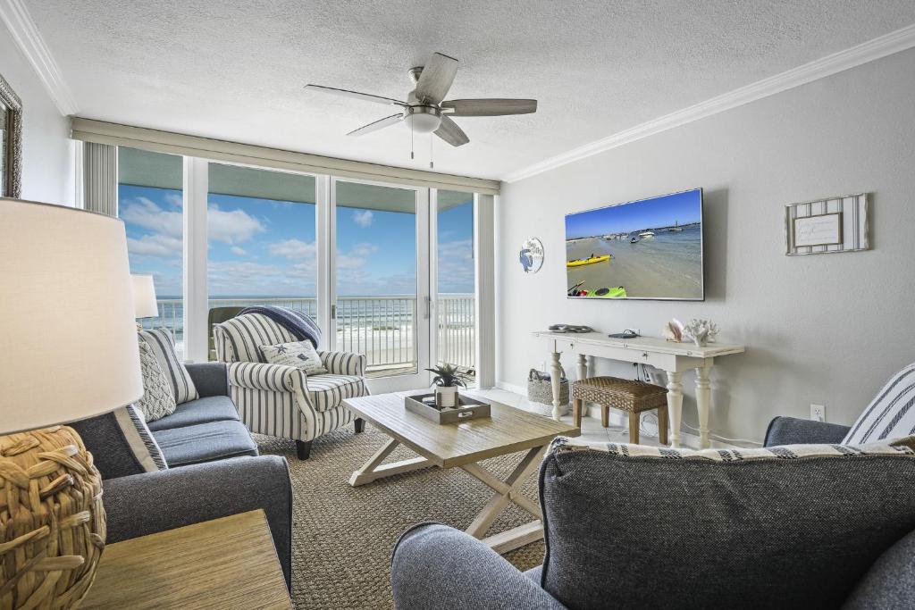 a living room with a view of the ocean at New listing! Direct oceanfront condo with a balcony, heated pool, and tennis court in Bottle Island