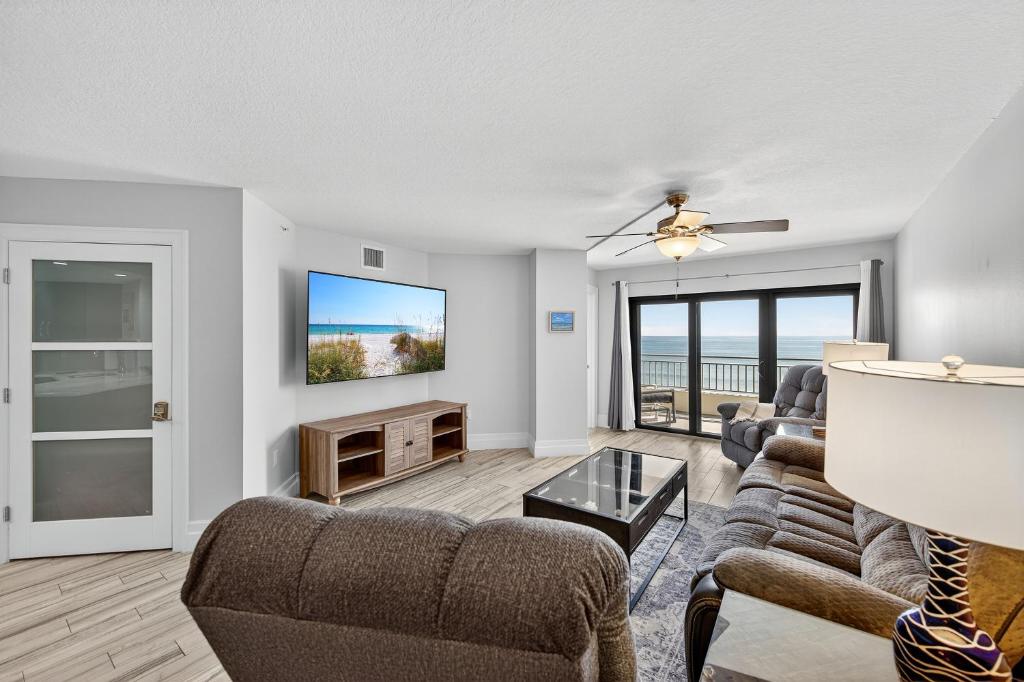 a living room with a couch and a tv at New listing! Direct oceanfront with private balcony, pool, and hot tub in Bottle Island