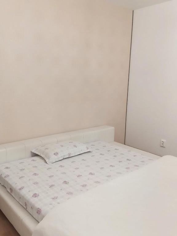a white bed with a pillow on top of it at Suita Brasonka in Braşov