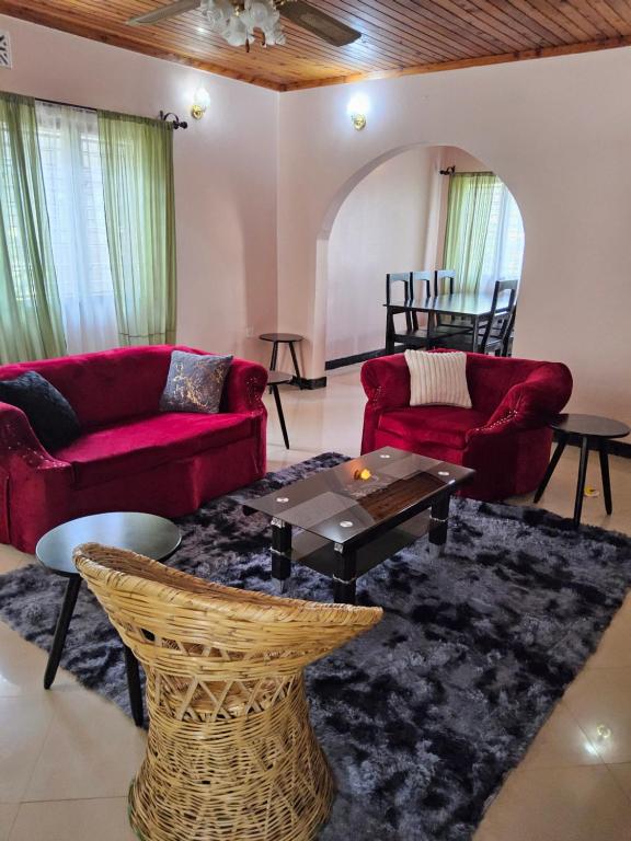 a living room with red couches and a table at Nestova Hostel in Nkunjila