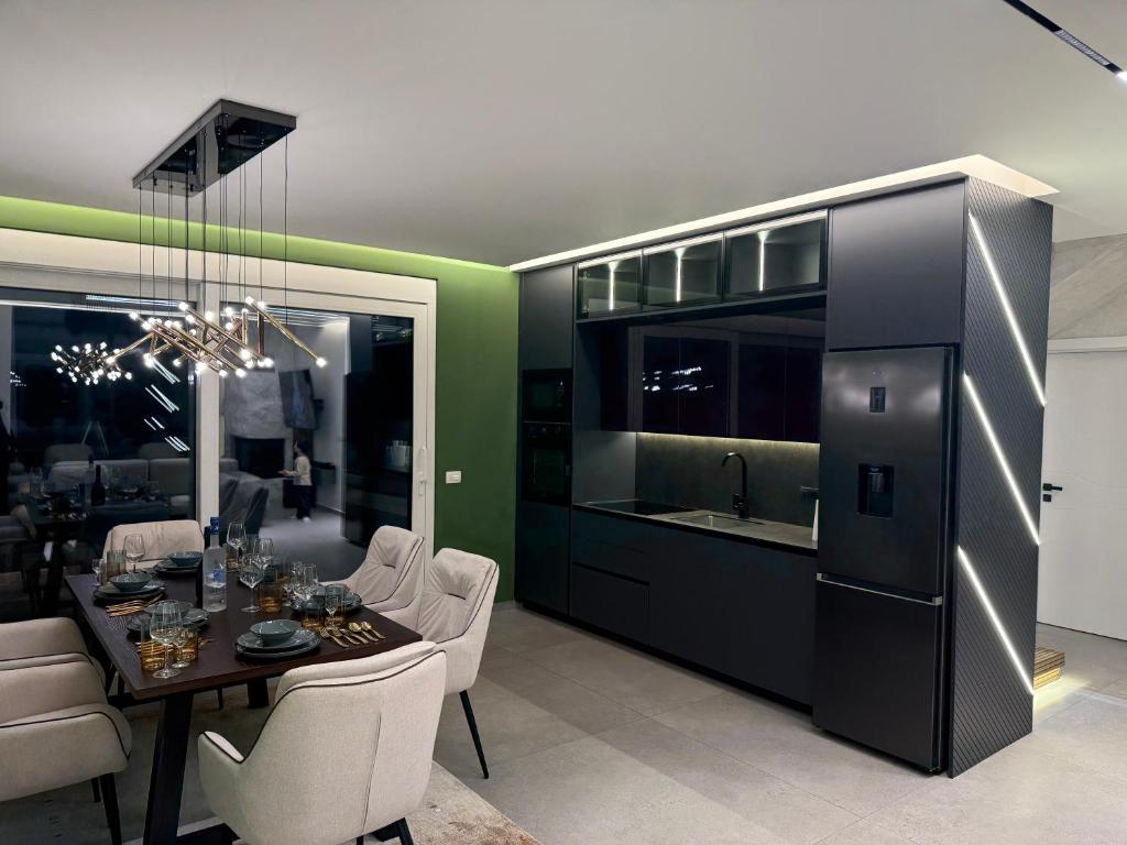 a kitchen and dining room with a table and chairs at Brezovica Lux in Brezovicë
