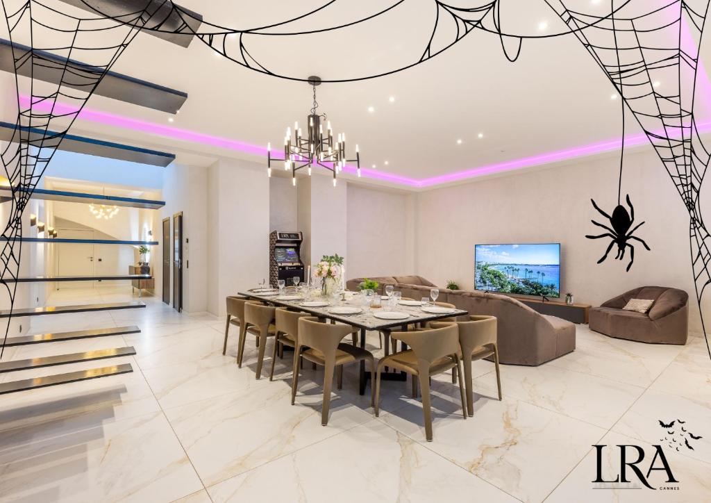 Un comedor con una mesa y un sofá. en Bliss Triplex - Hyper Centre - Sauna - BBQ - Jacuzzi - LRACANNES, en Cannes