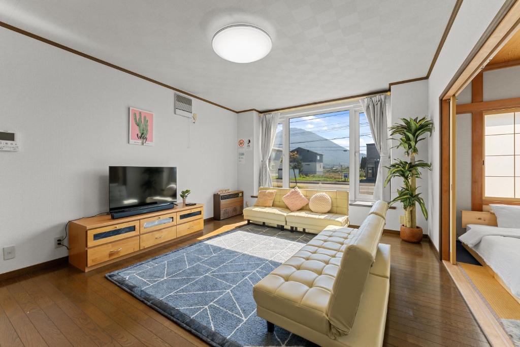 un salon avec un canapé et une télévision dans l'établissement Yotei View House, à Kutchan