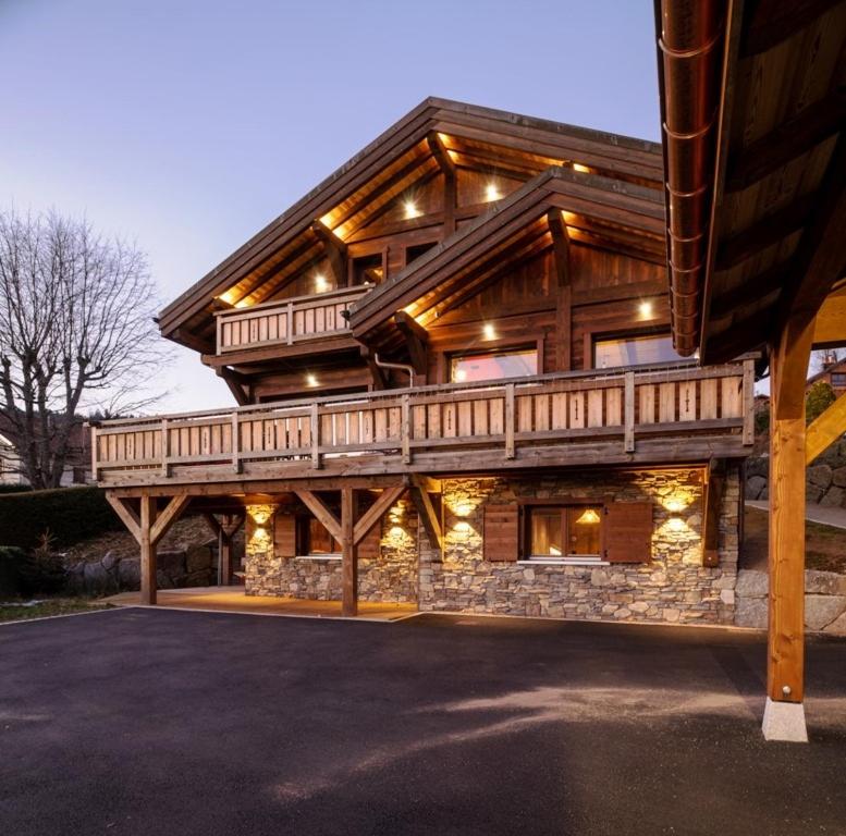 ein großes Holzhaus mit einer Terrasse darauf in der Unterkunft Chalet 1907, pleine vue lac in Gérardmer