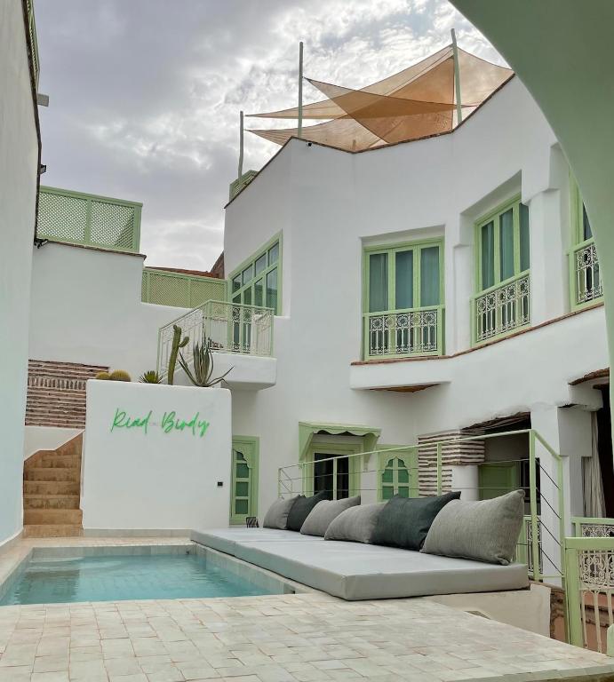 a villa with a pool in front of a building at Riad Birdy, Charmant et privatif, Piscine, Rooftop, 6 suites, 2 salons, Wifi in Marrakesh