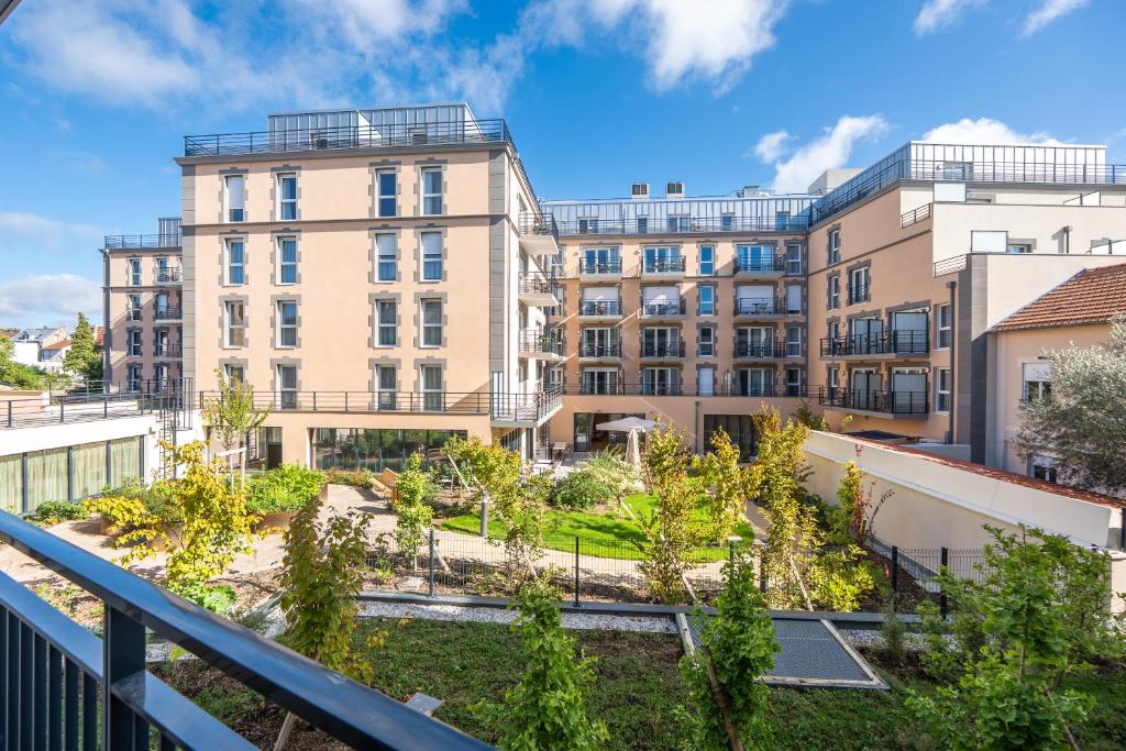 an apartment building with a garden on a balcony at Les Belles Lettres in Herblay
