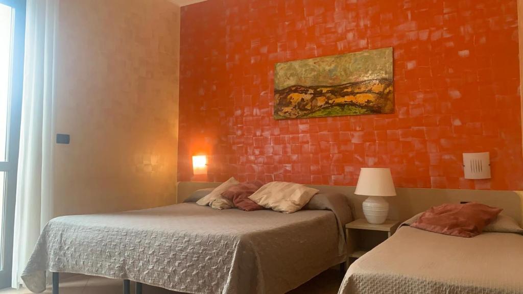 a bedroom with two beds and a brick wall at B&B al CASTELLO Torremaggiore in Torremaggiore
