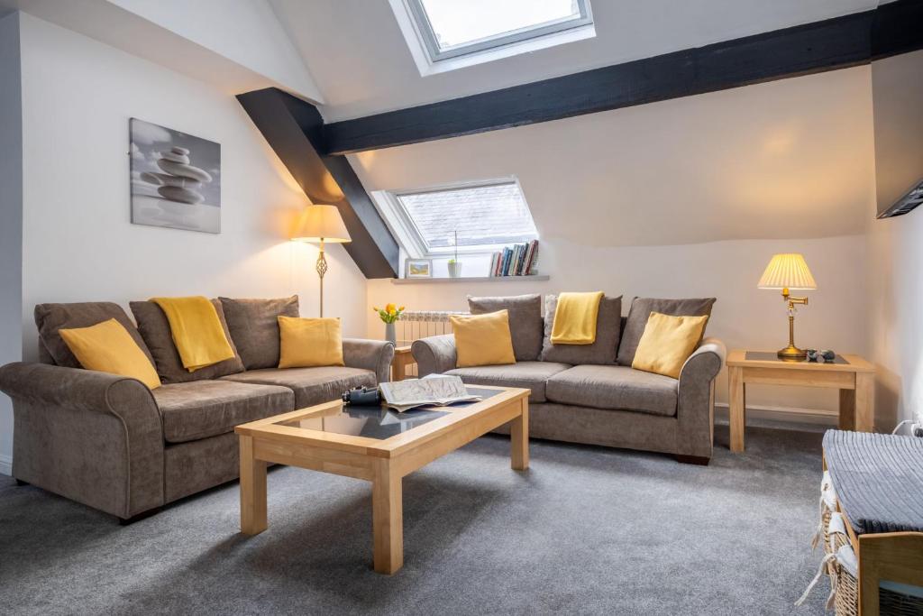 Una sala de estar con dos sofás y una mesa de café. en Old Stables Loft, en Kendal