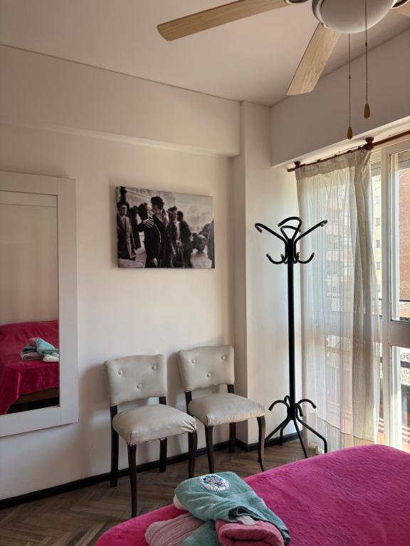 a bedroom with two chairs and a bed and a window at Bnb Loft XXIV in Rosario