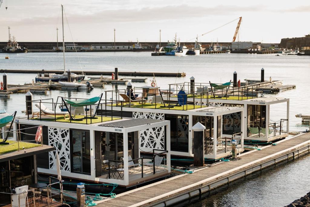 a boat is docked at a dock in the water at The Homeboat Company Ponta Delgada-Açores in Ponta Delgada