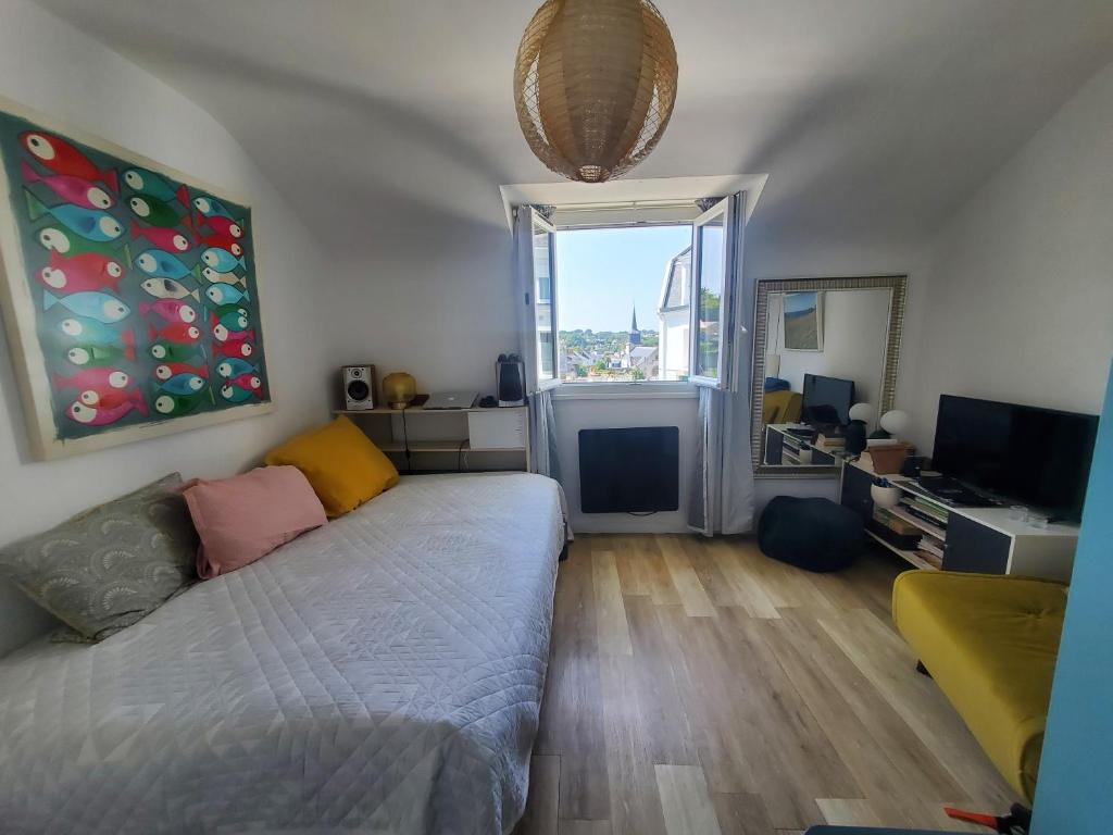 een woonkamer met een bed en een raam bij Bel appartement centre Le Palais in Le Palais