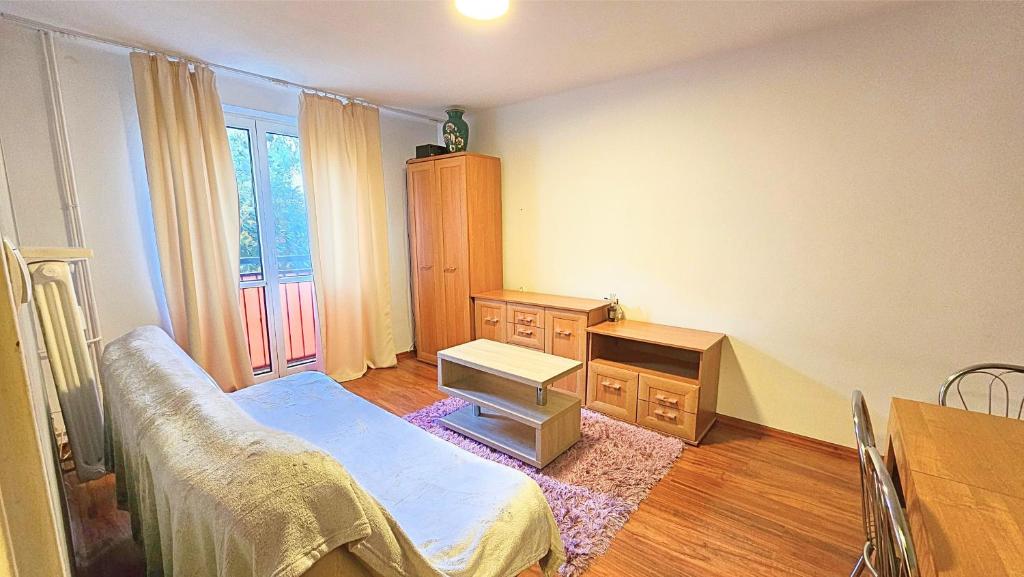 a bedroom with a bed and a dresser and a desk at Mieszkanie przy Parku in Łomża