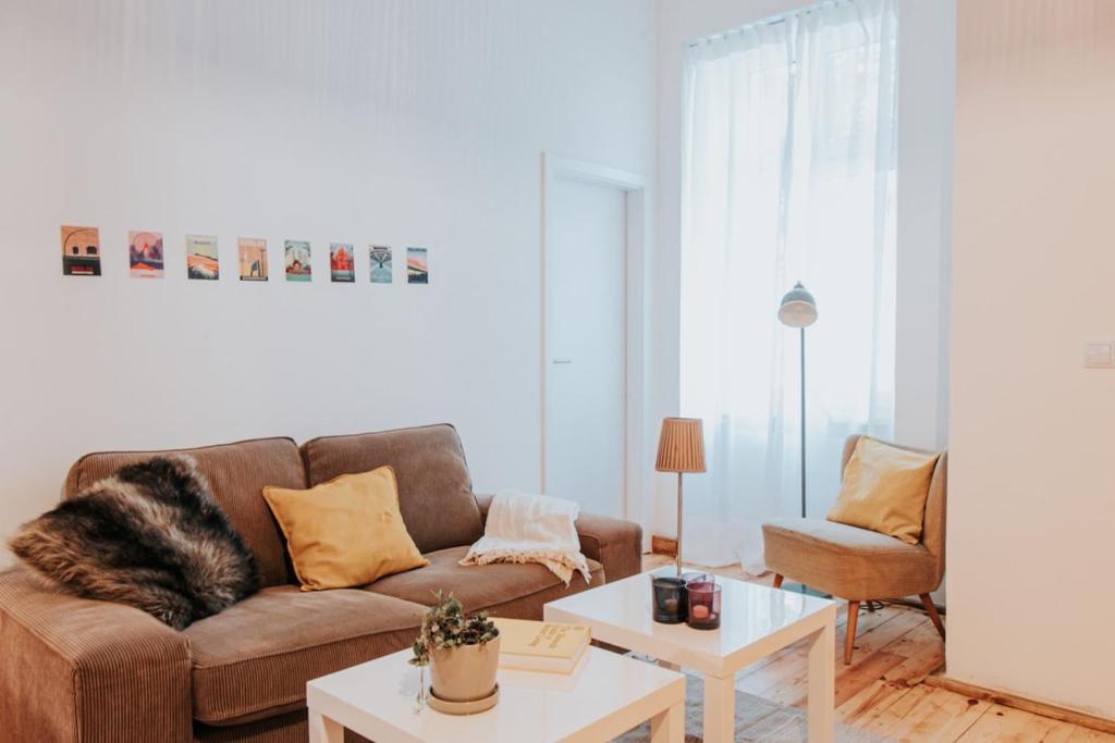 a living room with a brown couch and a table at Gaudyhouse in Berlin