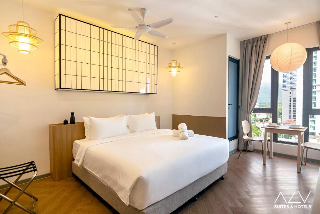 une chambre avec un grand lit blanc et une table dans l'établissement 22 Macalisterz by ALV, à George Town