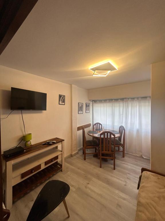 Una sala de estar con una mesa y un comedor. en Amplio monoambiente subdividido zona centro, en Pinamar