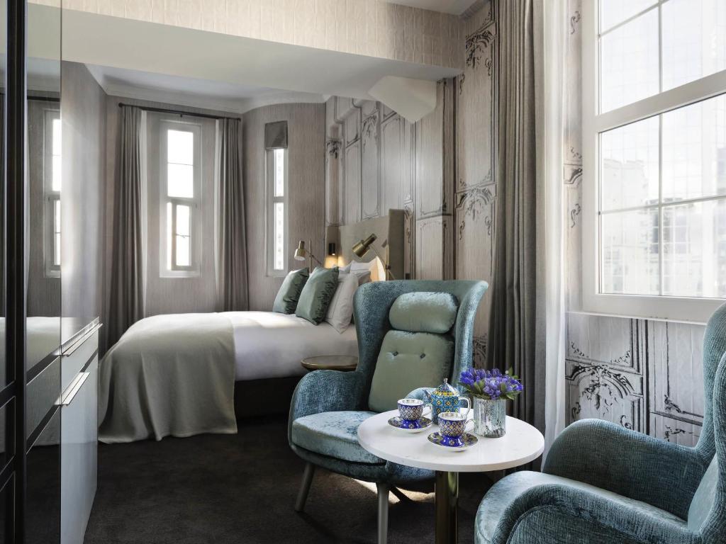 a bedroom with a bed and a table and chairs at Fable Auckland, MGallery in Auckland