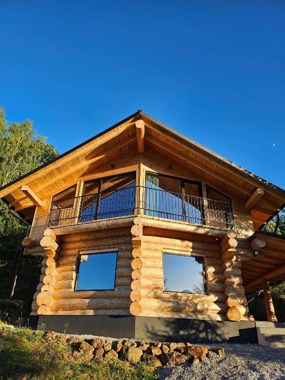a log cabin with a balcony on top of it at Cabana Cristi in Vatra Dornei