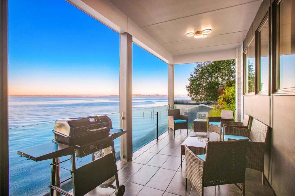a house with a balcony with a view of the water at Waterfront Haven with Spectacular View in Bainbridge in Rollingbay