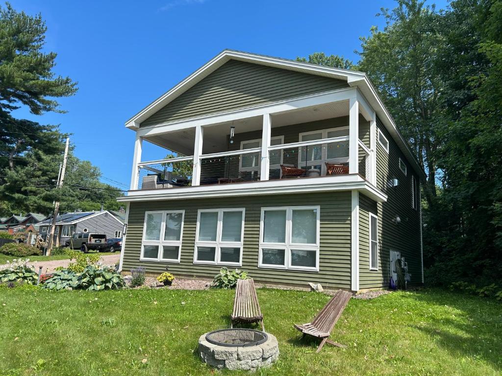 ein Haus mit einer Veranda und zwei Stühlen im Hof in der Unterkunft Roberts Lake House Room 2 & Room 3 & Upstairs in Colchester