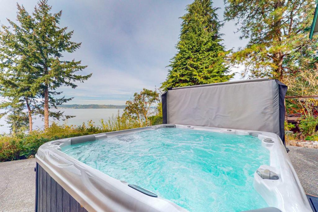 a hot tub in the backyard with a view of the water at Overlook Manor on Puget Sound in Federal Way