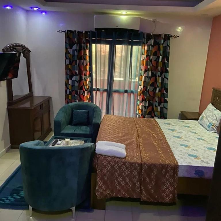 a hotel room with a bed and a chair at Chambre liberté 6 Dakar in Dakar