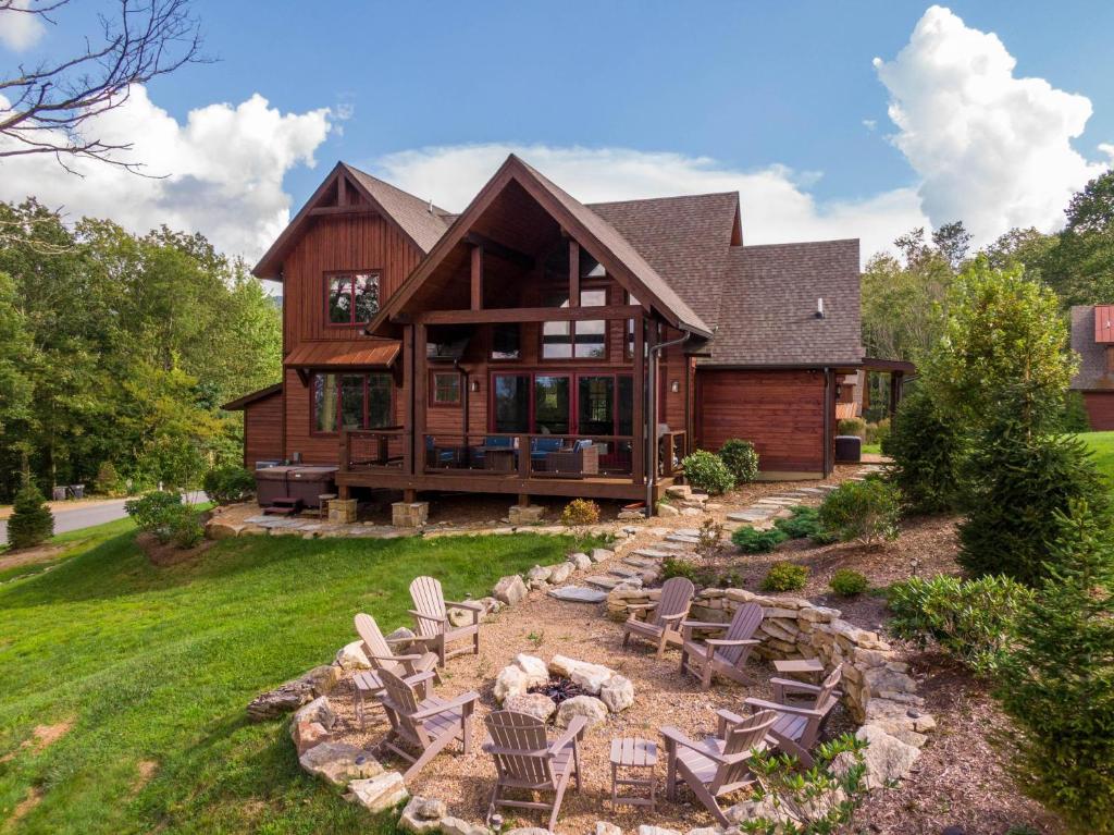 a house with chairs and a fire pit in the yard at Happy Trails at Eagles Nest in Elk Park
