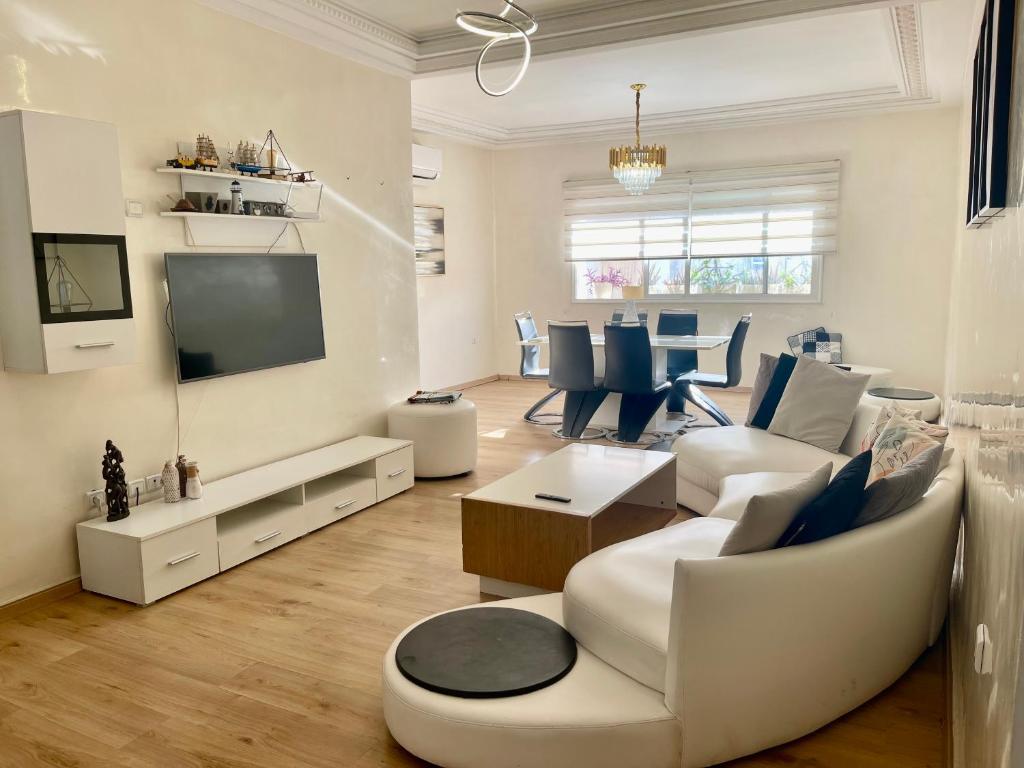 d'un salon avec un mobilier blanc et une télévision. dans l'établissement You'll be comfortable there!, à Fès
