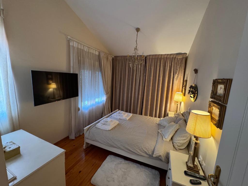 Un pequeño dormitorio con una cama y un televisor. en villa MeDITeRAN, en Pefkohori