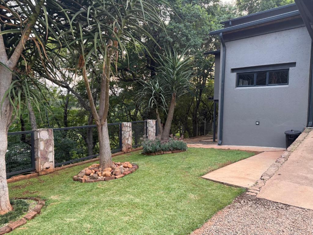 a yard with two trees and a fence at Bushview cottage 