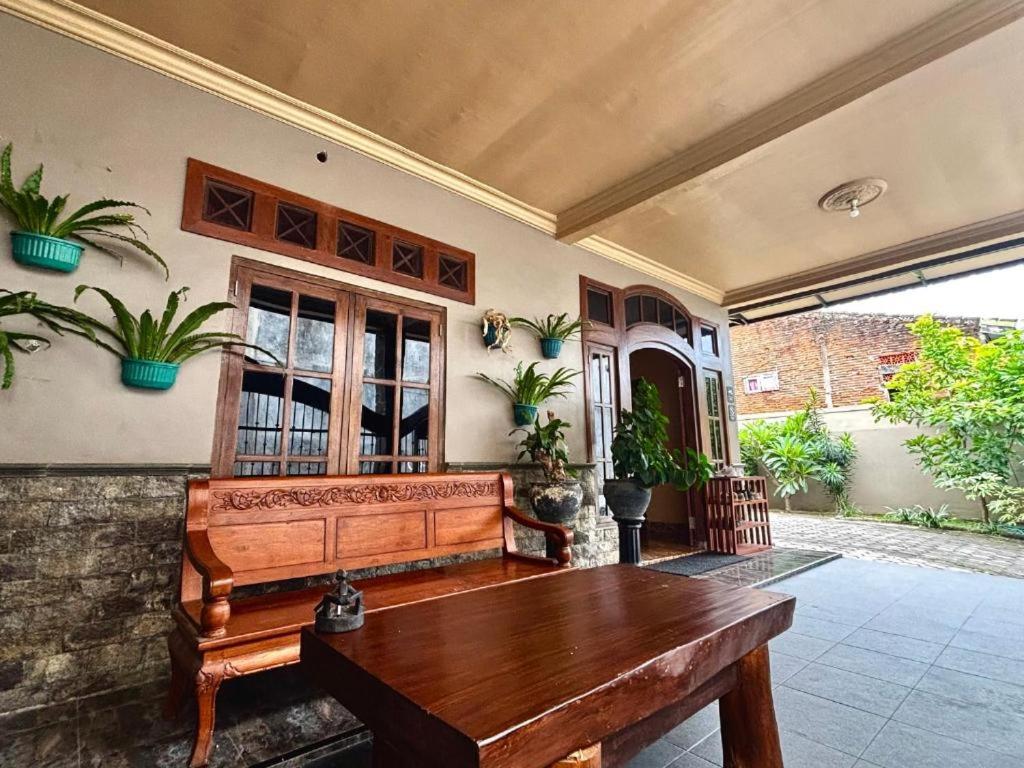 a house with a wooden bench in a courtyard at NOWORRIES Banyuwangi in Banyuwangi