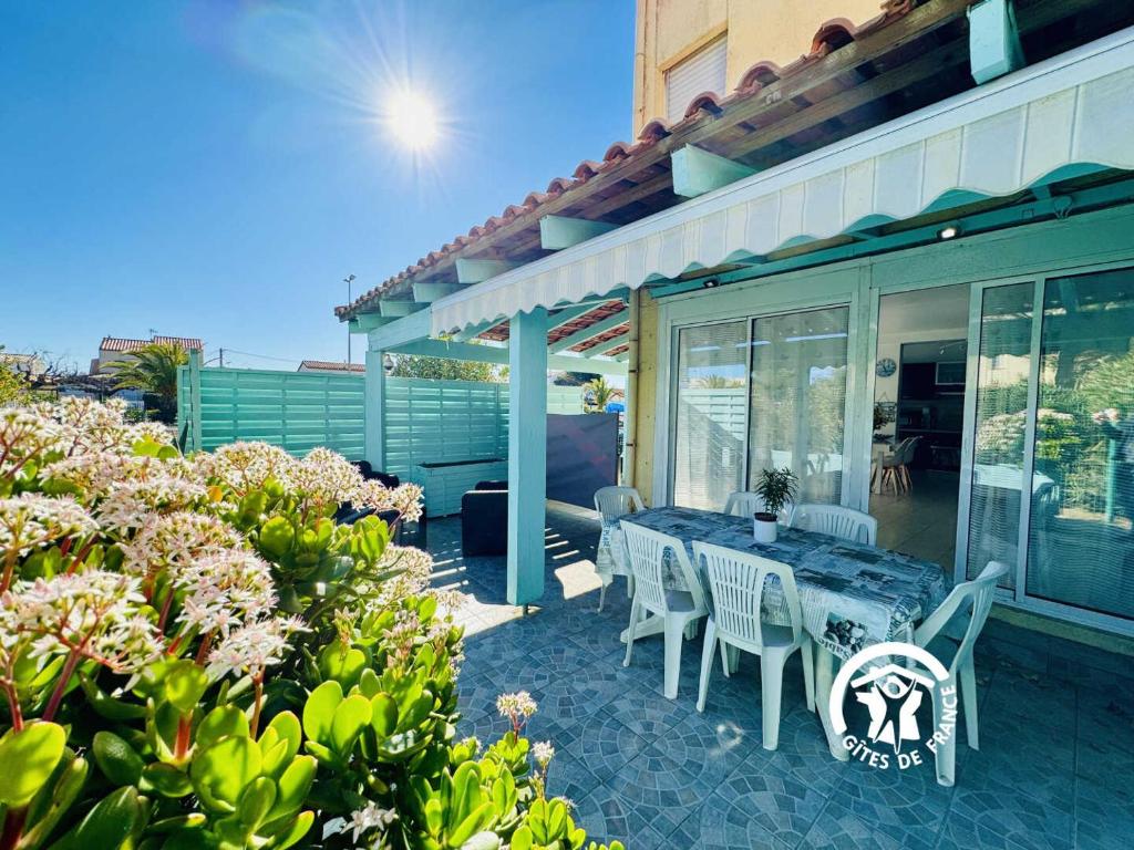 a patio with a table and chairs on a house at Le gite turquoise in Narbonne-Plage