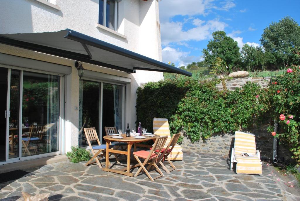 a table and chairs on a stone patio at la belle étape in Osséja